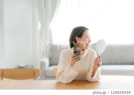 スマホを見て微笑む女性 スマホを見て微笑む女性 120038439