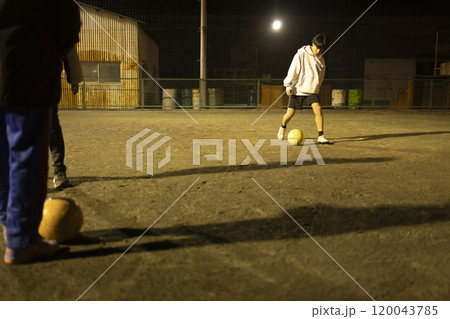 夜の公園でサッカーをする子供たち 120043785