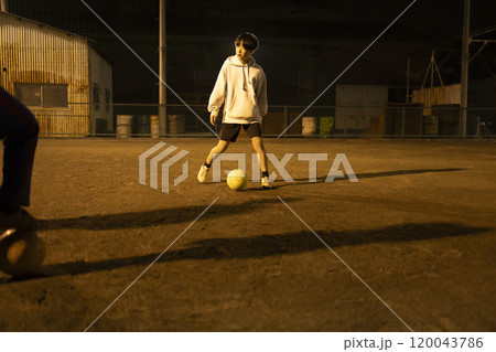 夜の公園でサッカーをする子供たち 120043786