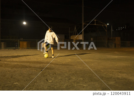 夜の公園でサッカーをする子供たち 120043911