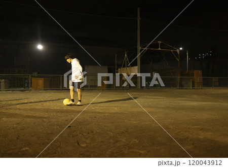 夜の公園でサッカーをする子供たち 120043912