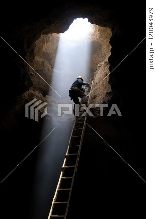 Life beneath earth: a mine worker focused on excavation in a subterranean environment showcasing the hard work, persistence, and skill involved in the mining profession. 120043979