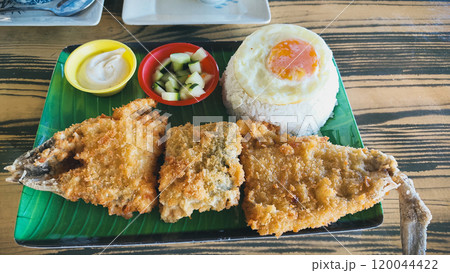 A plate of authentic local Filipino breakfast meal called bangsilog which is battered milkfish served with sinangag or garlic fried rice and egg A plate of authentic local Filipino breakfast meal called bangsilog which is battered milkfish served with sinangag or garlic fried rice and egg 120044422