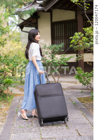 キャリーケースを引いて田舎に帰省する若い女性 旅行イメージ キャリーケースを引いて田舎に帰省する若い女性 旅行イメージ 120047174