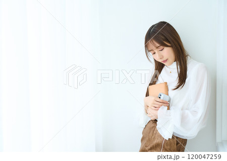 手帳とスマホを持つ若い女性　 120047259