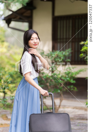 キャリーケースを引いて田舎に帰省する若い女性 旅行イメージ キャリーケースを引いて田舎に帰省する若い女性 旅行イメージ 120047337