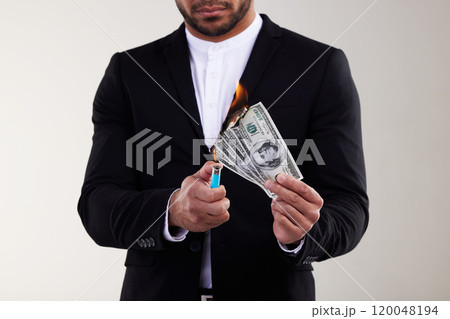 Businessman, hands and burning money with lighter for bankruptcy or financial loss in studio on white background. Closeup of man with dollar bills, cash or paper on fire for debt, tax or inflation 120048194