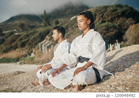 Calm people, karate and beach with meditation for martial arts, training or self defense in nature. Man and woman in zen, spiritual or awareness on rock by ocean coast for taekwondo or discipline 120048492