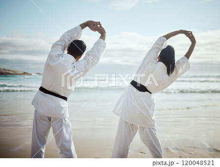Stretching, martial arts and people at beach for team training, flexible or back view. Ocean, karate and couple warm up for fight, fitness and warrior prepare healthy body for exercise lesson outdoor Stretching, martial arts and people at beach for team training, flexible or back view. Ocean, karate and couple warm up for fight, fitness and warrior prepare healthy body for exercise lesson outdoor 120048521