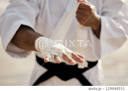 Hands, warrior and bandage wrapping fist for martial arts, training or exercise to prepare for karate match. Man tying gloves, fighter and getting ready for tournament, practice or beach workout 120048551