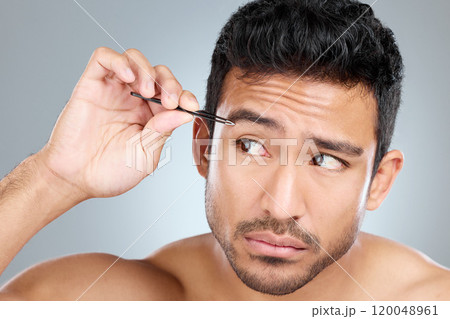 Man, idea and tweezers by eyebrow in studio for grooming, facial epilation and wellness or skincare. Male person, cosmetic tool and thinking of hair removal, gray background and hygiene routine. Man, idea and tweezers by eyebrow in studio for grooming, facial epilation and wellness or skincare. Male person, cosmetic tool and thinking of hair removal, gray background and hygiene routine. 120048961