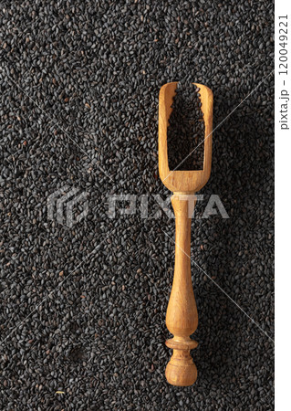Black sesame seeds and wooden spoon. 120049221