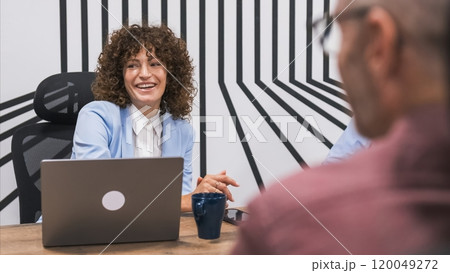 Cheerful businesswoman looking away with colleagues in conference room Cheerful businesswoman looking away with colleagues in conference room 120049272