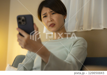 夜スマホを見て驚く若い女性 120050843