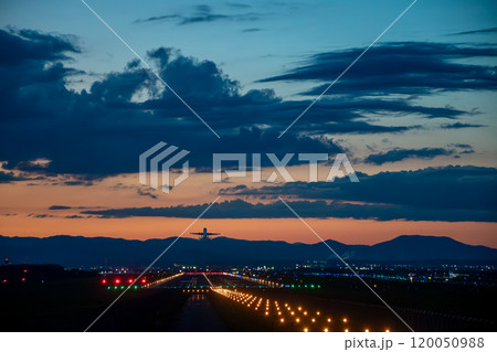夕暮れの空へ飛び立つジェット機 120050988