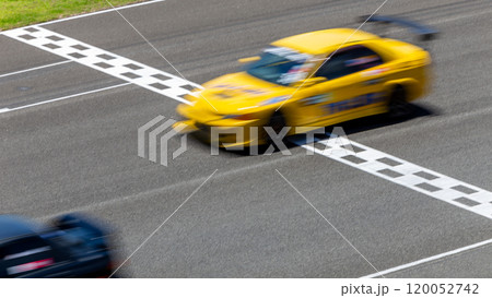 Motion blur race car racing on speed track, Car race on the international circuit race track crossing start and finish line, Race car crossing start and finish line, Target business achieve victory. 120052742