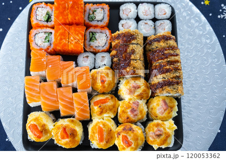 Delivery of sushi and rolls set top view on the table at home on a napkin, home cooking Delivery of sushi and rolls set top view on the table at home on a napkin, home cooking 120053362