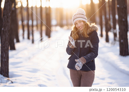 Happy young woman plays with a snow in sunny winter day. Girl enjoys winter, frosty day. Happy young woman plays with a snow in sunny winter day. Girl enjoys winter, frosty day. 120054310