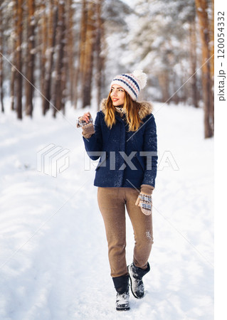 Happy young woman plays with a snow in sunny winter day. Girl enjoys winter, frosty day. 120054332