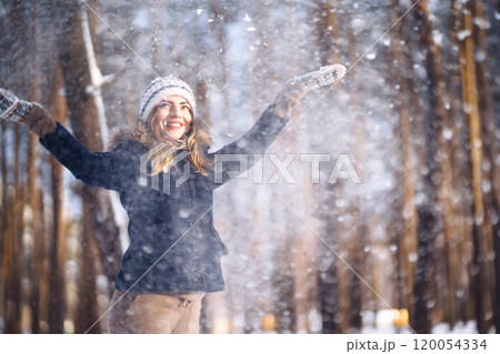 Happy woman plays with snow in sunny winter day. Girl enjoys winter, frosty day. Playing with snow. 120054334