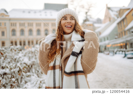 Beautiful woman playing with snow on winter street. Fashion young woman in winter park. Christmas. 120054416