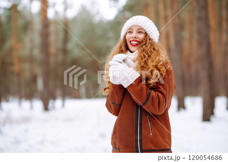Winter smiling woman stands among snowy trees in winter forest. Winter smiling woman stands among snowy trees in winter forest. 120054686