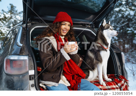 Young woman and cute husky dog enjoying outdoors into the car. Travel concept. Winter season. 120055054