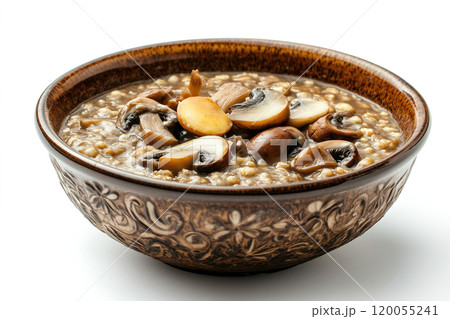 Warm bowl of hearty mushroom barley soup served in a decorative wooden bowl on a bright background 120055241