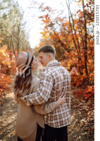 Couple in love newlyweds in casual clothes travel together, hike and walk in autumn forest in nature 120055793