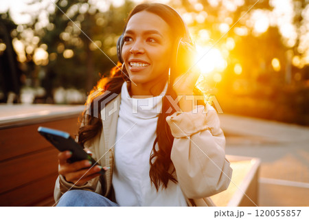 Young woman listens to music, audiobook or podcast. Communication in social networks. Lifestyle. 120055857