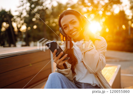 Young woman listens to music, audiobook or podcast. Communication in social networks. Lifestyle. Young woman listens to music, audiobook or podcast. Communication in social networks. Lifestyle. 120055860