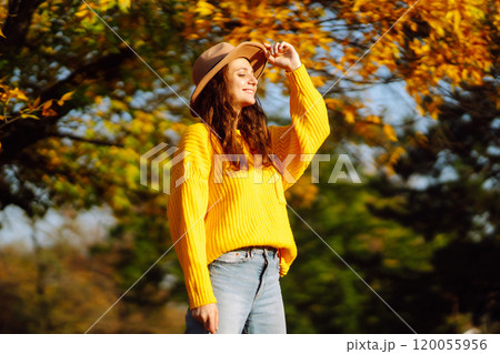 Young woman in a yellow sweater and jeans resting in nature. Fashion, style concept. People, lifestyle. Young woman in a yellow sweater and jeans resting in nature. Fashion, style concept. People, lifestyle. 120055956