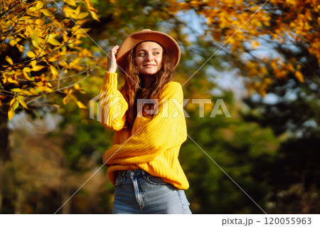 Young woman in a yellow sweater and jeans resting in nature. Fashion, style concept. People, lifestyle. 120055963