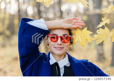 Beautiful young woman enjoying autumn day in nature, walking down the forest path covered with colorful fallen leaves and relaxing Beautiful young woman enjoying autumn day in nature, walking down the forest path covered with colorful fallen leaves and relaxing 120057346