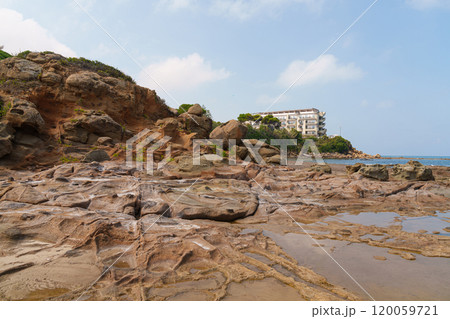 Rocky Coastal Terrain with Residential Building in the Distance Rocky Coastal Terrain with Residential Building in the Distance 120059721