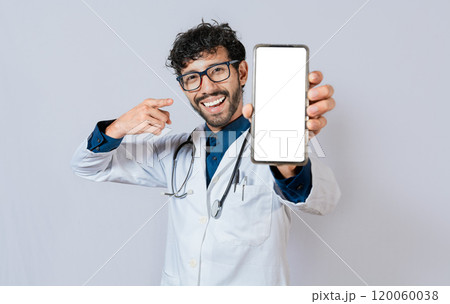 Happy doctor showing cell phone screen to camera. Smiling doctor showing cell phone screen pointing finger isolated. 120060038