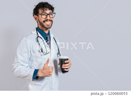 Young doctor holding a coffee to go isolated. Smiling doctor holding coffee with thumb up, Satisfied doctor holding takeaway coffee isolated Young doctor holding a coffee to go isolated. Smiling doctor holding coffee with thumb up, Satisfied doctor holding takeaway coffee isolated 120060055