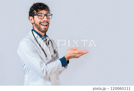 Smiling doctor showing something with his palms. Young doctor presenting something with palms isolated, Handsome doctor showing an advertisement with his palms Smiling doctor showing something with his palms. Young doctor presenting something with palms isolated, Handsome doctor showing an advertisement with his palms 120060111