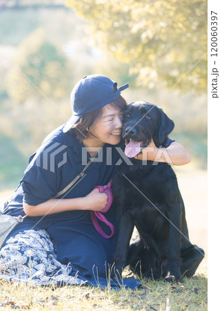 紅葉や秋の葉ががきれいな場所でペットの大型犬と飼い主の女性 全身 紅葉や秋の葉ががきれいな場所でペットの大型犬と飼い主の女性 全身 120060397