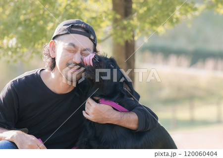 紅葉や秋の葉が場所でペットの大型犬と寄り添う仲良しな飼い主の男性 コピースペースあり 舐められる 紅葉や秋の葉が場所でペットの大型犬と寄り添う仲良しな飼い主の男性 コピースペースあり 舐められる 120060404