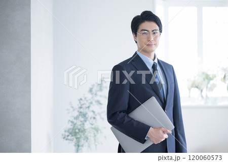 税理士、会計士、コンサルタントの士業などパソコンを持ってカメラ目線の若いビジネスマン 税理士、会計士、コンサルタントの士業などパソコンを持ってカメラ目線の若いビジネスマン 120060573