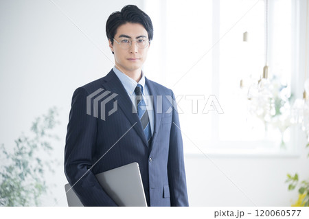 税理士、会計士、コンサルタントの士業などパソコンを持ってカメラ目線の若いビジネスマン 税理士、会計士、コンサルタントの士業などパソコンを持ってカメラ目線の若いビジネスマン 120060577