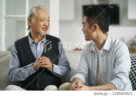asian elderly father and adult son chatting at home 120060925