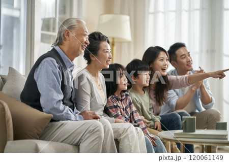 three generation asian family watching tv together at home three generation asian family watching tv together at home 120061149