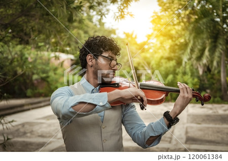 Portrait of man playing violin at sunset. Close up of violinist man playing in the street. Violinist artist playing a melody outdoors, Image of a person playing the violin outdoors Portrait of man playing violin at sunset. Close up of violinist man playing in the street. Violinist artist playing a melody outdoors, Image of a person playing the violin outdoors 120061384