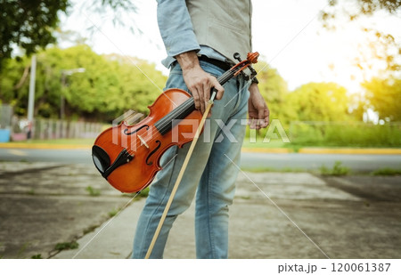 Hands holding violin and hoop outdoors, Close up of hands holding violin and hoop. Concept of person holding violin and hoop outdoors 120061387