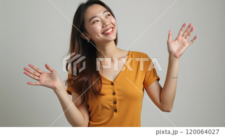 Asian Woman Happily Pointing to Upper Side with Both Fingers in Studio Asian Woman Happily Pointing to Upper Side with Both Fingers in Studio 120064027