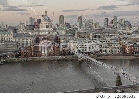 Aerial view of St Paul Cathedral and The skyscrapers with Thames river and Millennium Bridge on foreground before sunset. 120069033