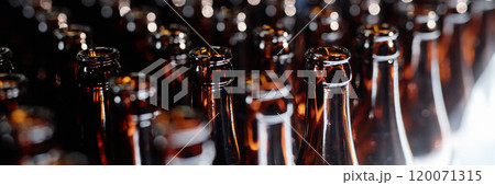 Header image of dozen open glass bottles shining in light at production line in craft beer factory, copy space Header image of dozen open glass bottles shining in light at production line in craft beer factory, copy space 120071315