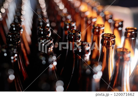 Background shot of dozen open glass bottles shining in light while standing in lines at craft beer factory, copy space Background shot of dozen open glass bottles shining in light while standing in lines at craft beer factory, copy space 120071662